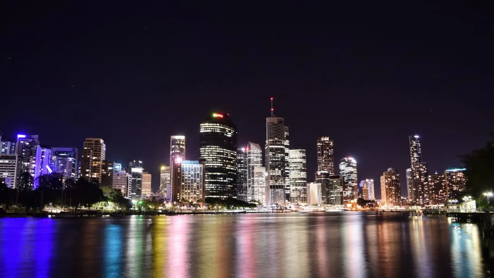 City skyline lit up at night over the water