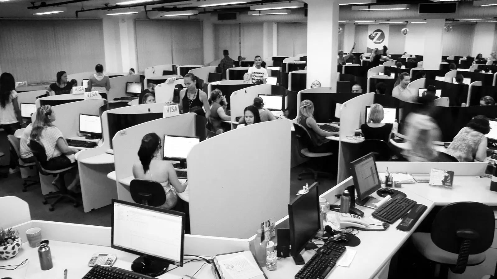 Rows of call center workstations with agents on headsets