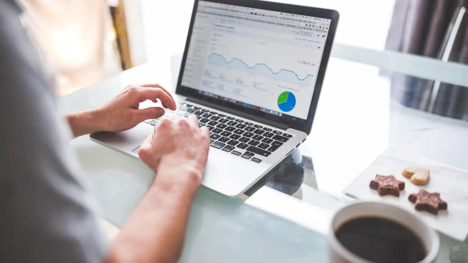Laptop showing an analytics dashboard beside a cup of coffee