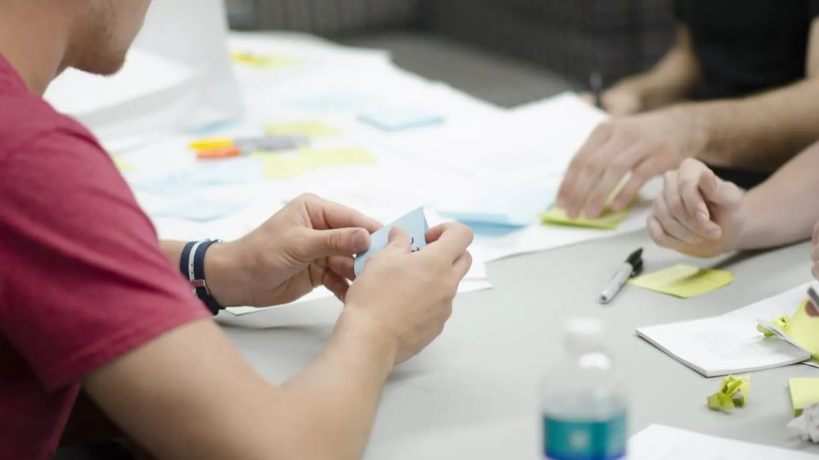 Team sorting sticky notes on a table during planning