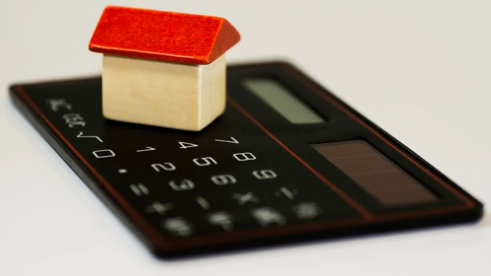 Small model house sitting on a calculator