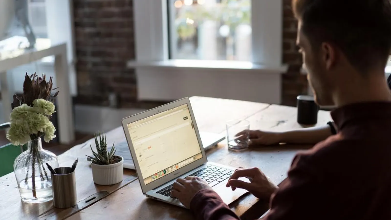 Salesperson working on a laptop at a wooden desk