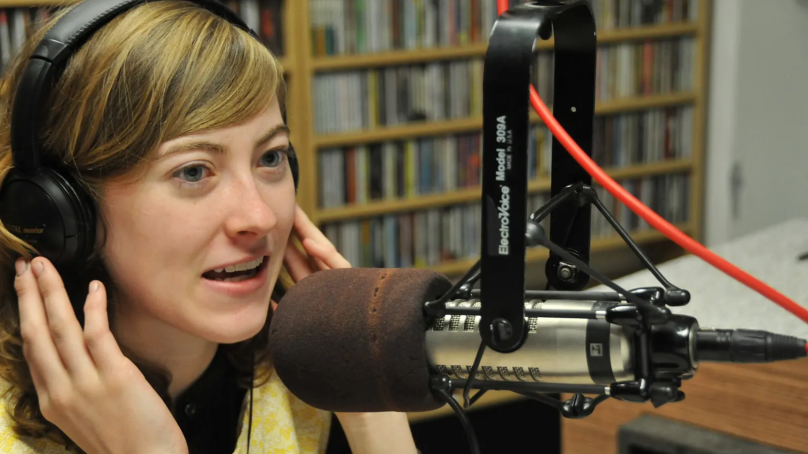 Radio host speaking into a broadcast microphone