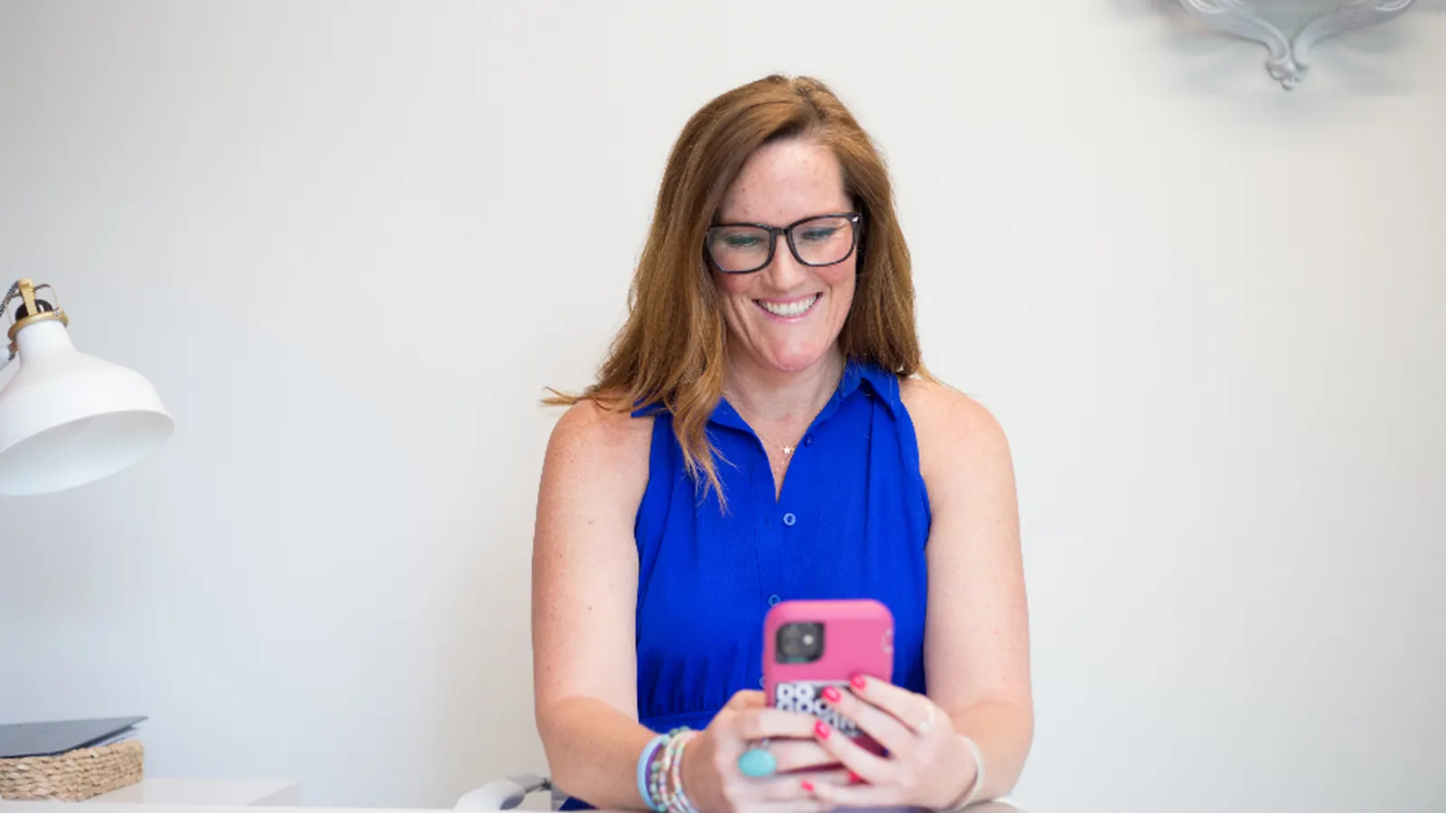 Woman checking her phone at a desk