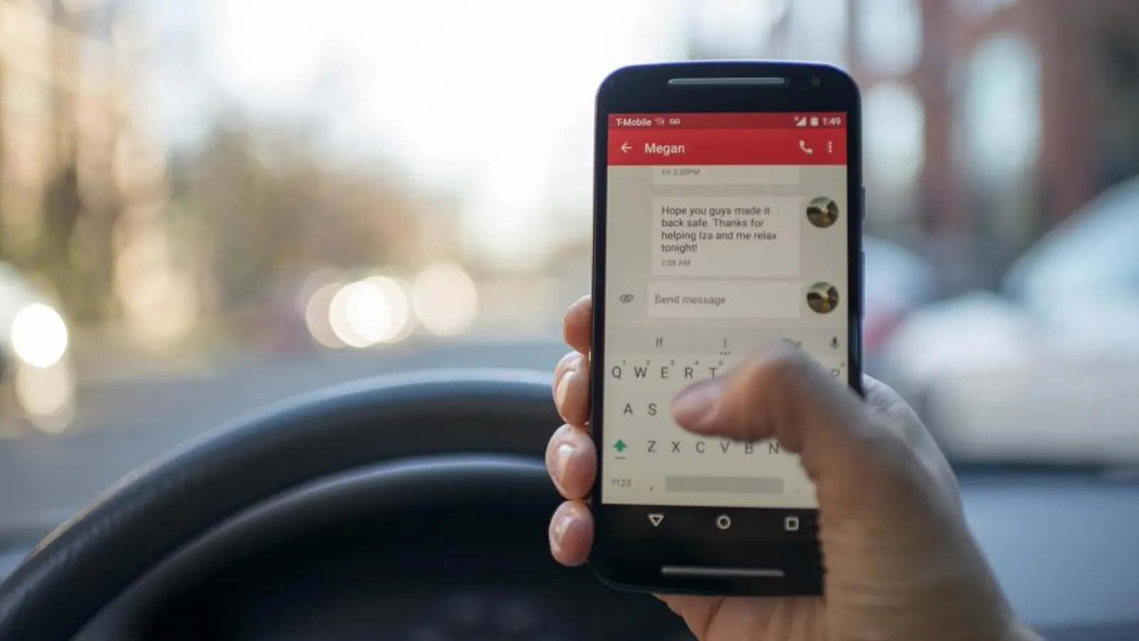 Driver holding a smartphone while sitting in a car