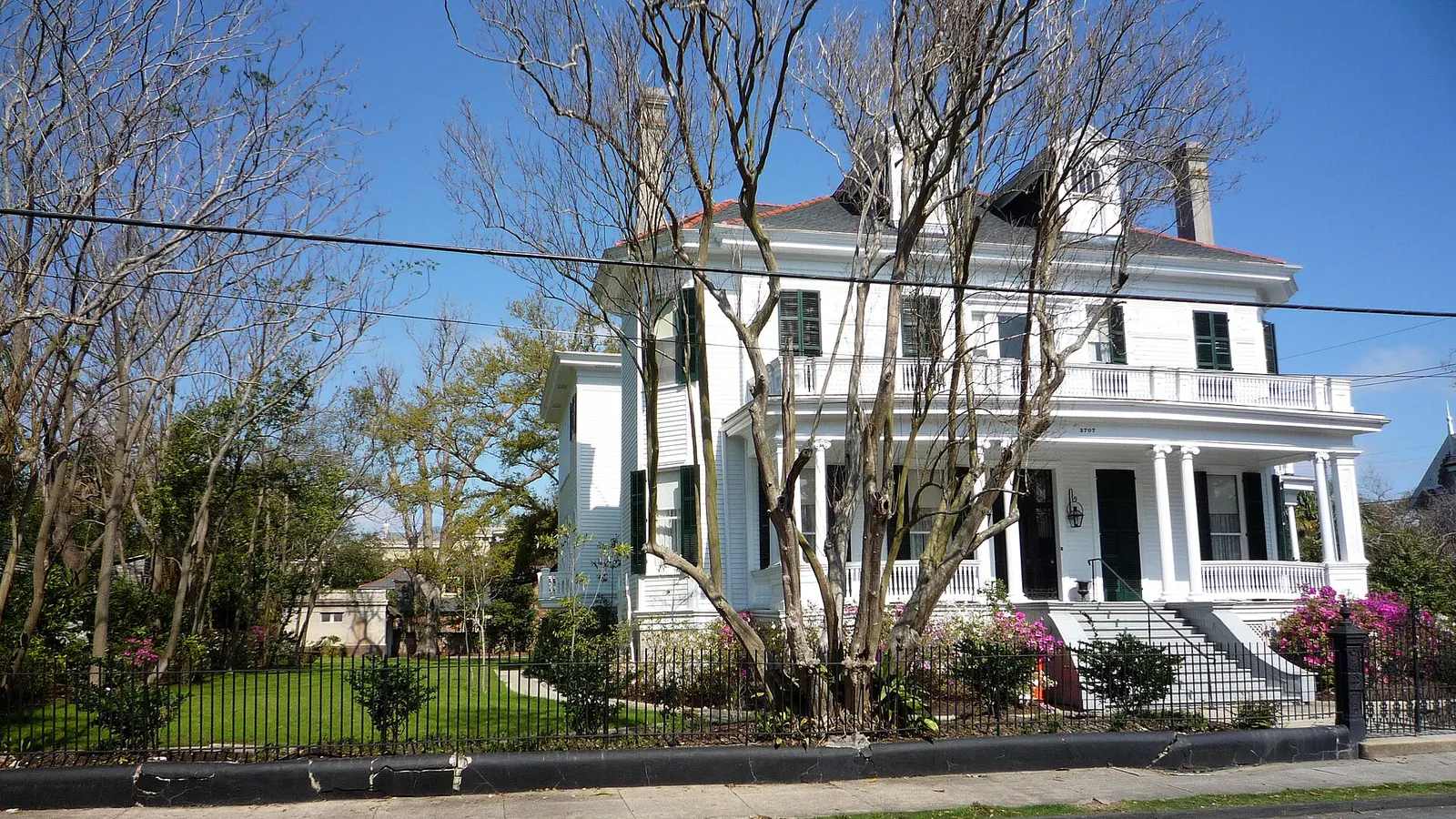 Large white house with a porch and front lawn