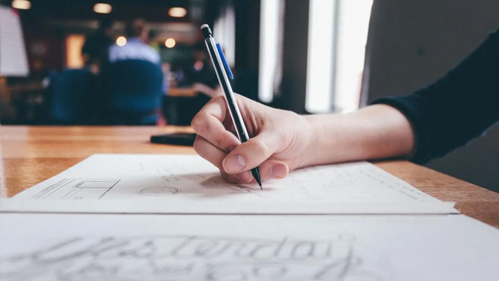 Person writing notes on paper at a desk